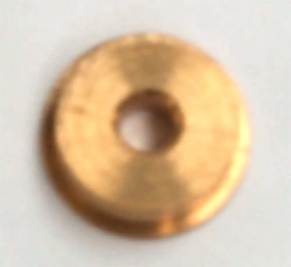 Daikin Gas Membran in einem runden, flachen Design mit zentralem Loch, aus Metall mit goldener Farbe, auf hellem Hintergrund.